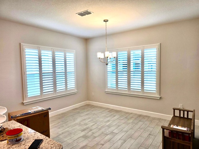 Plantation shutters on corner windows in a dining room