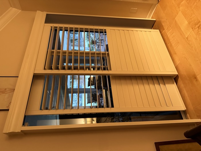 Plantation shutters on sliding glass doors overlooking a lake